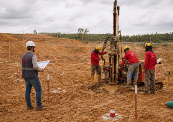 Equipe da APL Engenharia realiza sondagem geotécnica em canteiro de obras com sonda de investigação, pontos de sondagem demarcados no terreno e engenheiro analisando planta de locação dos furos.